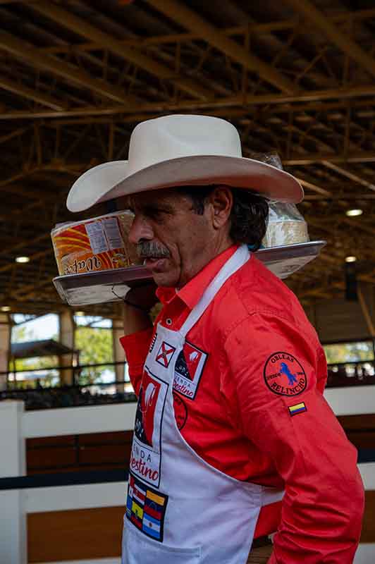 man selling food with a cowboy hat on