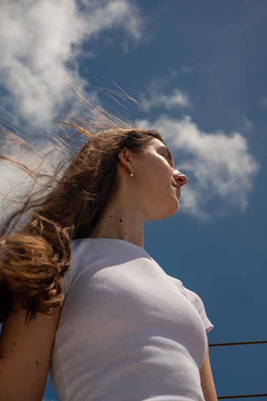 girl with clouds in the sky behind her